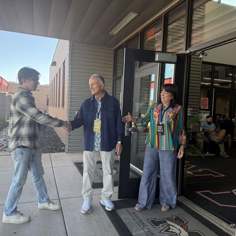 A greeter welcomes a guest at the door of Riverwood Elementary